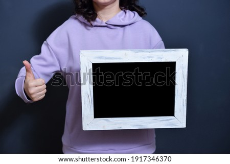 young girl holding a frame with metosm for the test. concept of sales and black friday after pandemic.