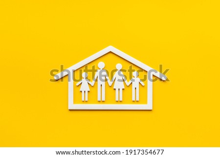 Family at home concept. Wooden family figure in white house. Top view