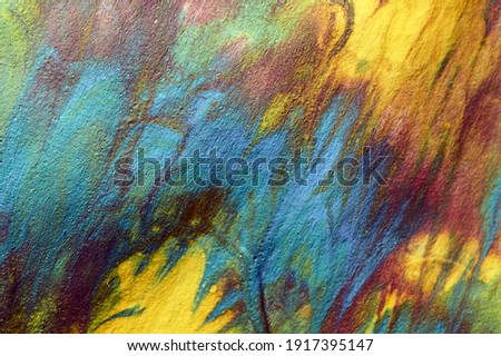 Macro shot of a mix of acrylic paint and oil on a marbled paper background.