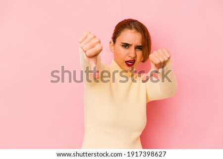Young arab mixed race woman showing thumb down and expressing dislike.