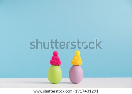 Easter holiday concept with cute eggs with funny faces. Different emotions and feelings. Lovely couple in hats.