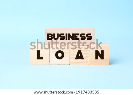 Wooden blocks with the words Business Loan. The concept of low mortgage rates. Real estate market., Housing. Credit. Business and Finance