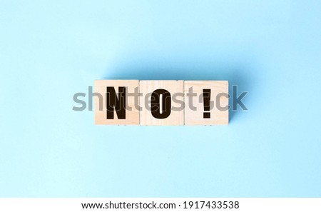 Wooden cubes with text no on a blue background. Negative answer concept. No risk, no violence or no discrimination concept