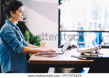 Contemplative copywriter in casual wear sitting at coworking desktop and thinking about content idea while doing distance job on laptop computer, Caucaisan woman with netbook pondering on web design
