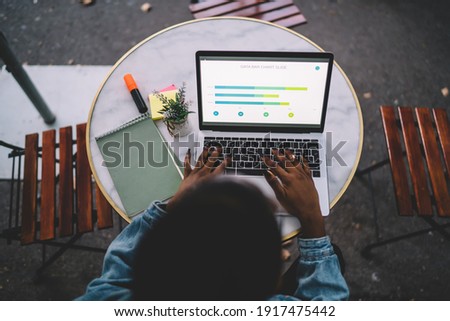 Top view of female student e learning trade accounting during online courses on laptop computer, skilled woman checking diagram statistics while projecting using 4g internet on netbook technology Royalty-Free Stock Photo #1917475442