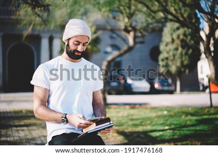 Turkish male blogger checking received text messages browsing website for chatting on smartphone device, Middle Eastern hipster guy making online booking and banking via cellphone application