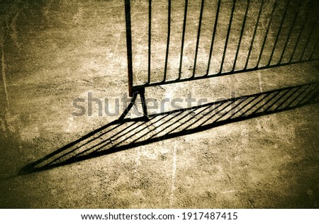 A shadow of a temporary metal barrier