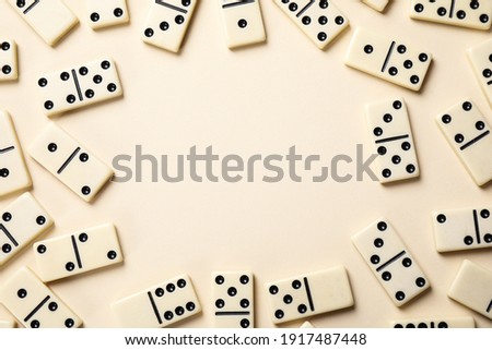 Frame of classic domino tiles on beige background, flat lay. Space for text