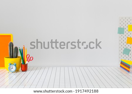 Student creative desk mock up with colorful office supplies, laptop and white wall. Back to school. Royalty-Free Stock Photo #1917492188