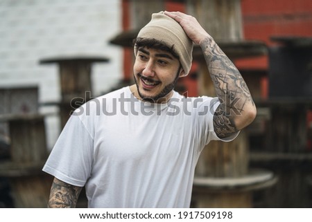 A shallow focus shot of a posing handsome smiling European guy in a hat