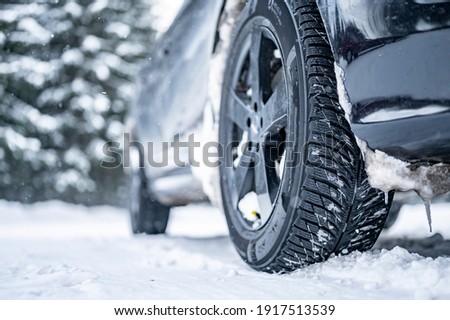 Winter tire. Detail of car tires in winter on the road covered with snow.