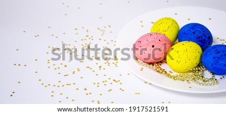multicolored eggs on a white background covered with sparkles. easter holiday concept