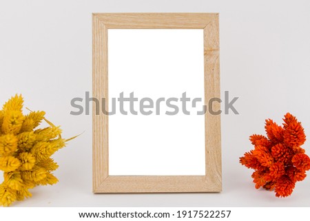 a photo frame on white background with branches of red and yellow leaves