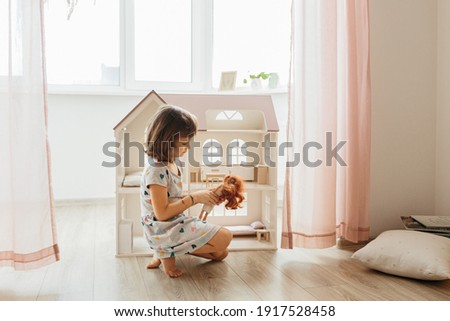 Girl playing with doll house in children room Royalty-Free Stock Photo #1917528458