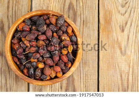 Dried rose hips in wooden bowl, natural vitamin C. Studio Photo