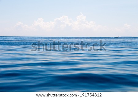 ocean surface and blue sky with clouds