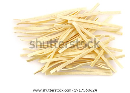 Raw food Italian Macaroni. Pasta on white background. Egg homemade dry ribbon noodles. Close-up. There is some free space for your text or sign.