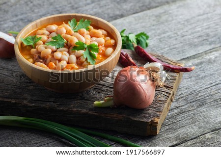 Traditional turkish food,  dried white beans with tomato paste in plate on wooden background Royalty-Free Stock Photo #1917566897