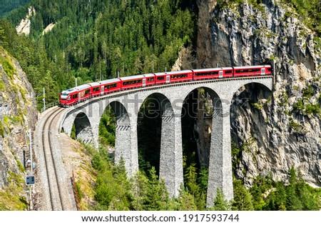 Passenger train crossing the Landwasser Viaduct in the Swiss Alps Royalty-Free Stock Photo #1917593744