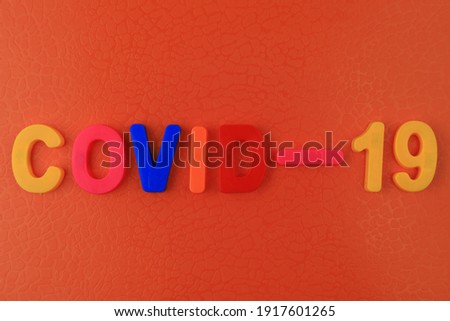 A word or text Covid-19 written in a childrens alphabet with classic letters on a magnet.