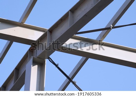 Selective focused structure steel beam prepared support roofing of building. Blue sky background. Concept of steel beams, structure, bar, metal pillar, metal sting, building construction, skeleton.