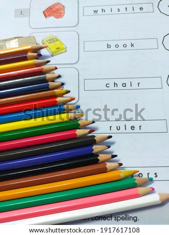 Variety of color pencils on preschool homework worksheet. 
