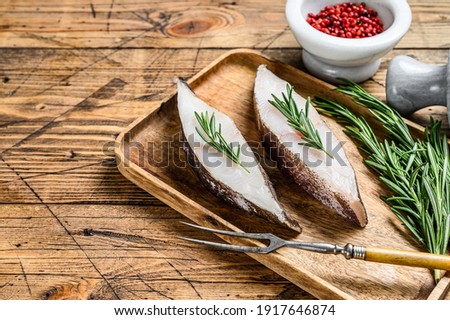 Raw halibut saltwater fish steak. wooden background. Top view. Copy space