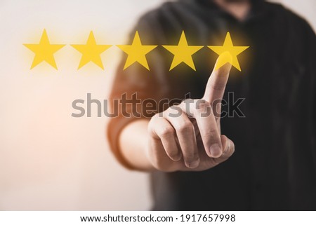 Customer review good rating concept hand pressing five star on visual screen and positive customer feedback testimonial Royalty-Free Stock Photo #1917657998