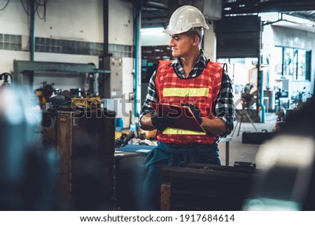 Manufacturing worker working with clipboard to do job procedure checklist . Factory production line occupation quality control concept .