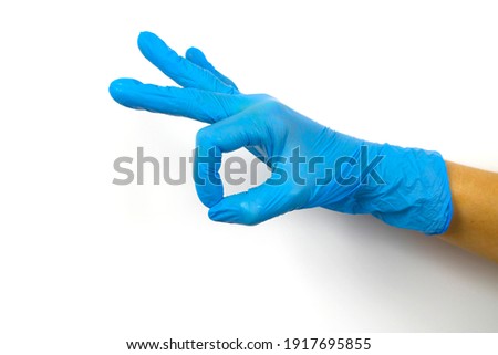 OK sign with a hand in a blue medical glove on a white background. Means of protecting medical workers from viruses. Coronavirus pandemic prevention.