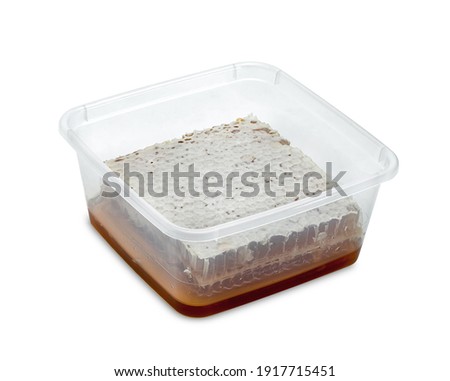 Fresh Honeycomb slice and honey in plastic box isolated on white background 