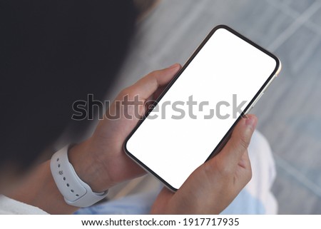 Mockup image of woman hand using and looking at blank white screen mobile smartphone, close up, vintage tone