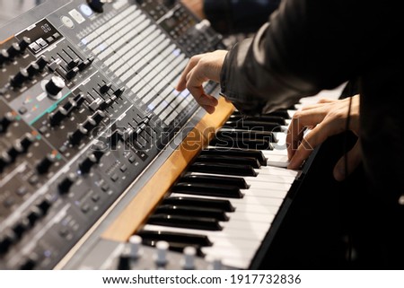 Playing music on the keyboard of a modern analog synthesizer. Selective focus. Royalty-Free Stock Photo #1917732836