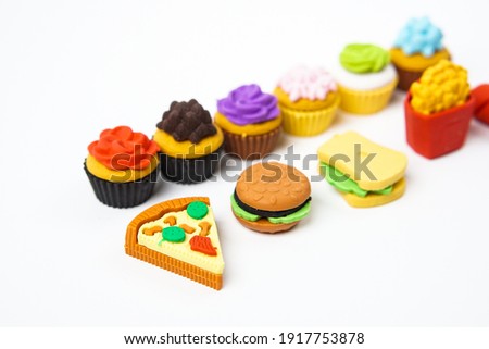 View of miniature toy kitchenware and foods on white background. Image with selective focus and  flat lay.