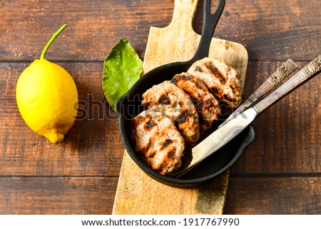 Home made Grilled sausage patties. Meatballs  and fresh lemon on wooden rustic background