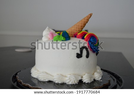 Side view of a unicorn birthday cake looking to the right.
