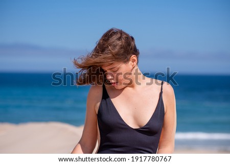 Portrait of woman at beach with ocean in background