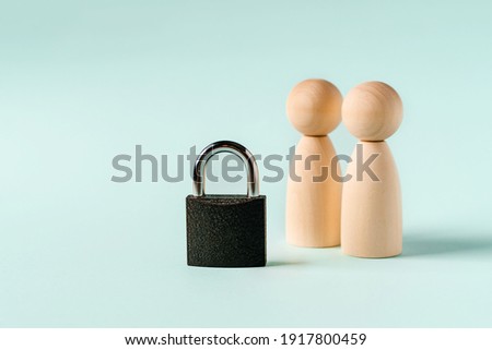 Wooden figures of people and a padlock. The concept of protecting and preserving secrets. Protection of information networks.