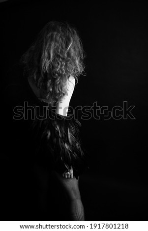  girl in feathers,  beautiful cape made of raven feathers on a slender female body, black and white fashion photo