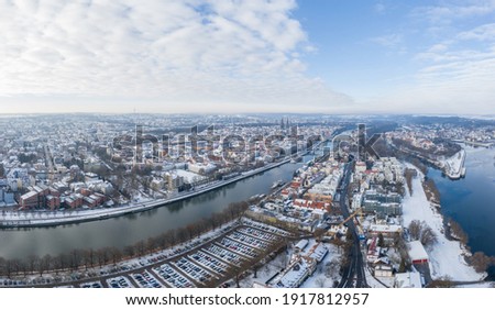 Panorama of Regensburg city in Bavaria with the river Danube the cathedral and the stone bridge in winter with snow and ice, Germany