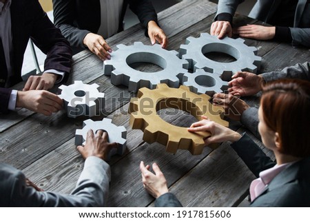 Business people connect gear together at meeting table, success cooperation teamwork concept Royalty-Free Stock Photo #1917815606