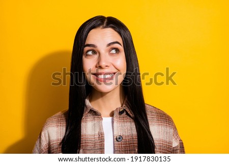 Photo of young cheerful girl happy positive smile dream dreamy look empty space isolated over yellow color background