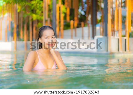 Portrait beautiful young asian woman relax smile enjoy leisure around swimming pool in hotel resort