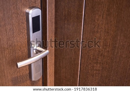 Lock with magnetic key close-up. A wooden door with an electronic lock. Key card hotel door lock system. Fragment of a door with a magnetic bolt.