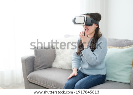 attractive asian woman using VR headset in the living room