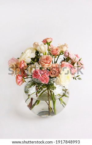 Beautiful flowers in vase on a table with white background. Women's, mother's day, love concept. Spring, summer season. Front view.