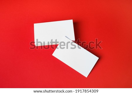 Photo of blank business cards on red paper background. Template for ID.
