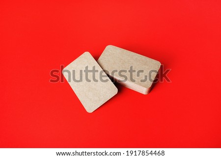 Blank kraft business cards on red paper background. Blank template for branding identity.