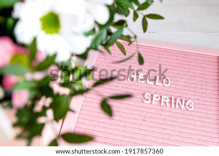 Text Hello Spring on the pink letter board with beautiful blooming flowers, minimalism style composition, copy space for your text