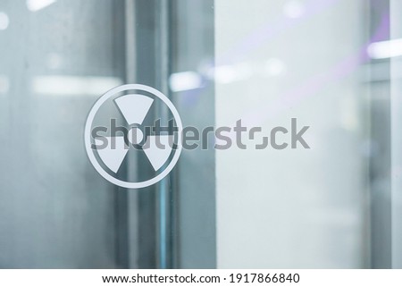 Radiation zone sign sticker on window of laboratory room. Health and safety concept Royalty-Free Stock Photo #1917866840